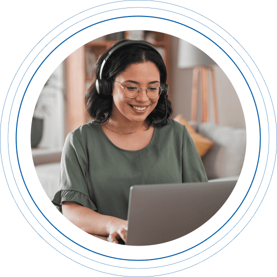 Young female Charles River Labs employee wearing headphones working from home on a laptop computer