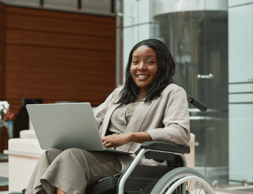A female Charles River professional in a wheelchair working on a laptop computer