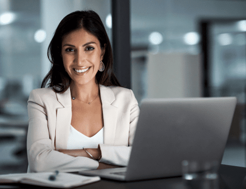 Smiling female Charles River professional sitting in front of a laptop computer.
