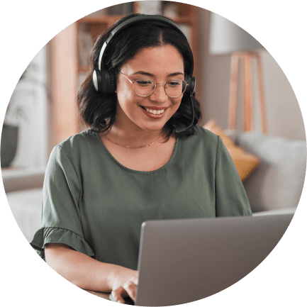 Young woman wearing headphones working from home on a laptop computer