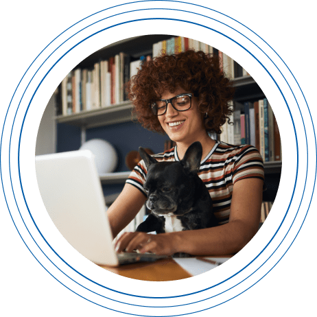 Young female student at a laptop with a dog in her lap