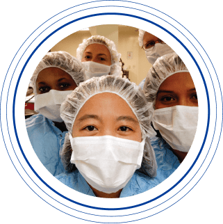 Close-up of a group of female Charles River laboratory science professionals wearing masks and caps