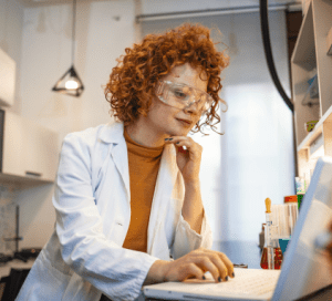 Scientist in a lab coat working on a laptop in a laboratory
