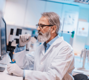 Scientist wearing a lab coat analyzing data on a computer in a laboratory